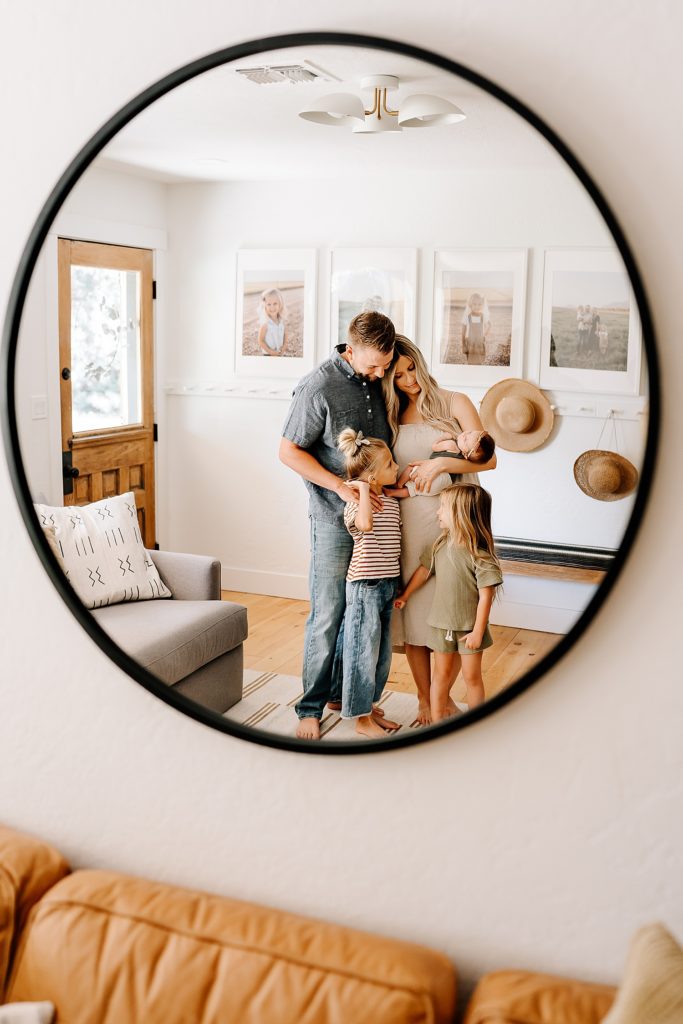 Picture of a new family of 5 in a mirror in their living room. 