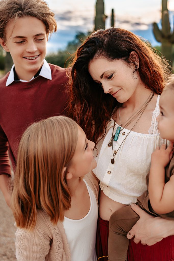 Mom looking at her children fondly for this boho family session with single mother.