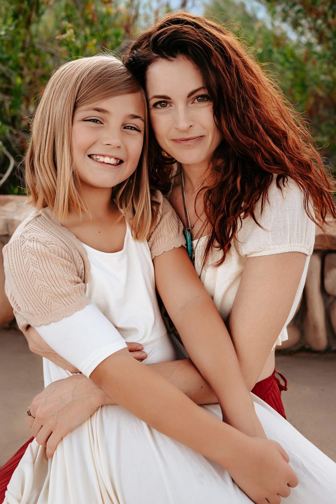 Mother and daughter smiling at the camera for their family session at Riparian Preserve.