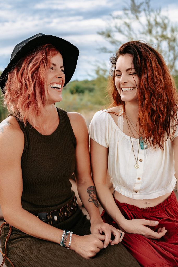 Adult sisters laughing together for this boho family session at Riparian Preserve in Arizona.