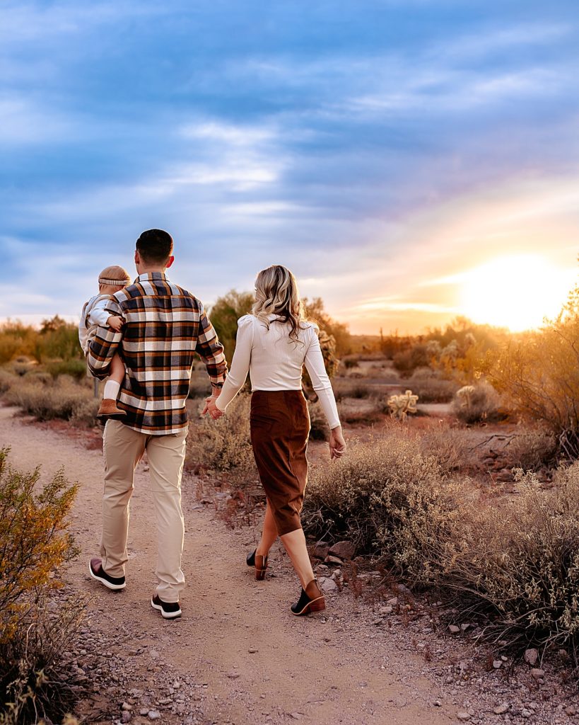 Family of three walking off into the sunset in Arizona. 
